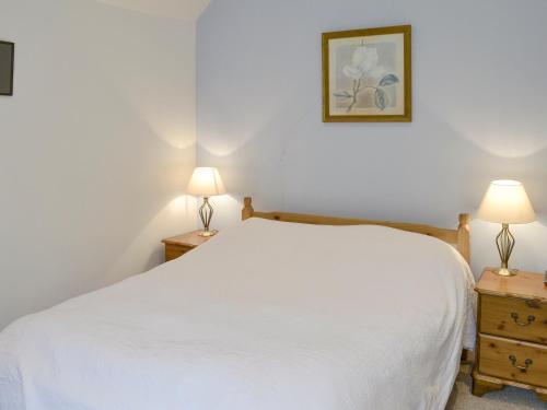 KilmelfortにあるCuil Lodgeのベッドルーム(白いベッド1台、ランプ2つ付)