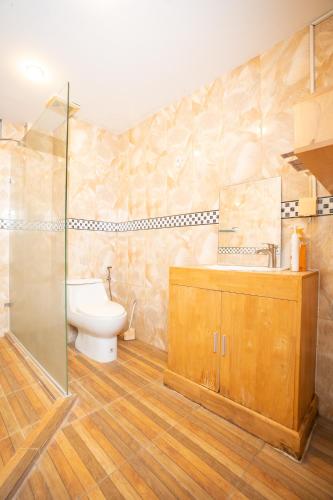 a bathroom with a toilet and a sink and a shower at Gvai Apartment in Phnom Penh