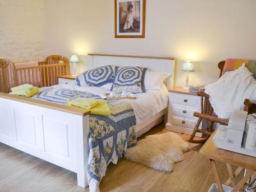 a bedroom with a bed and a table with a night stand at Glendale Cottage in Haltwhistle