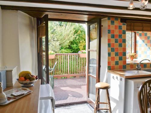 una cocina con una puerta corredera de cristal que da a una terraza en Fordbrook Cottage, en Brixton