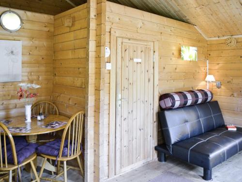 a dining room with a table and a leather chair at Crabtrees in Felindre