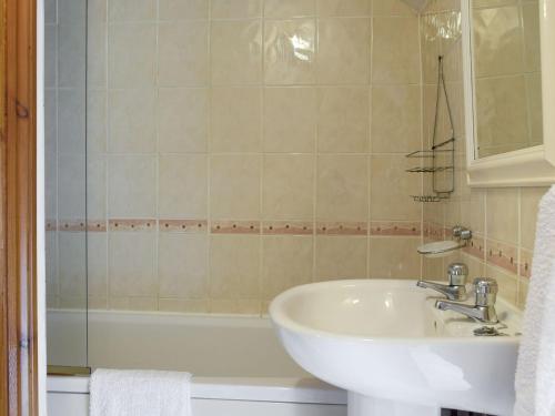 a bathroom with a sink and a bath tub at The Cottage in Cross Hands