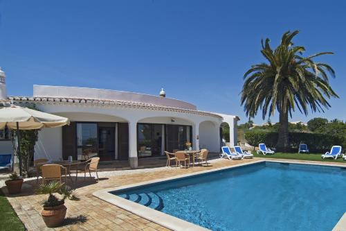 a villa with a swimming pool in front of a house at Villa Camena, private pool, sea view, residential area outside of the village Praia da Luz in Luz
