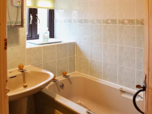 a bathroom with a bath tub and a sink at Bradley House in Harrop Fold