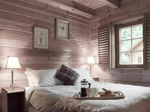 1 dormitorio con paredes de madera y 1 cama con bandeja. en Alder - Uk5502, en Killin