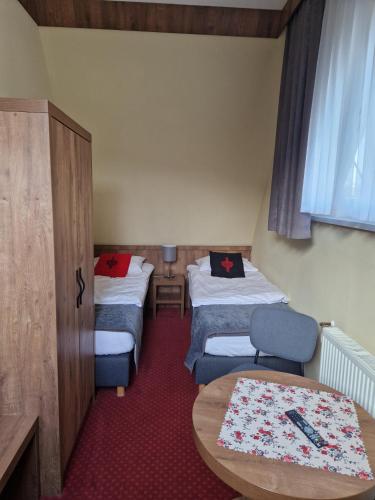 a small room with two beds and a table at Magnolia in Zakopane