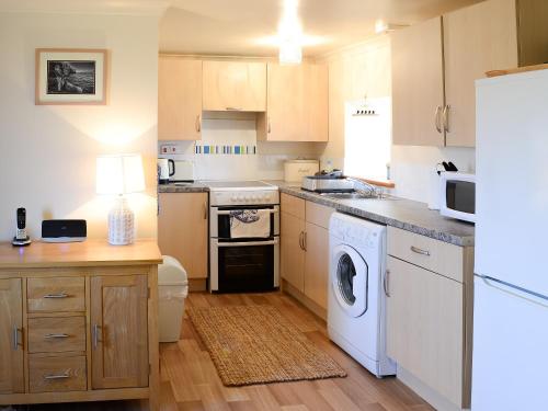 a kitchen with a washer and dryer at Eagle Cottage in Culkein