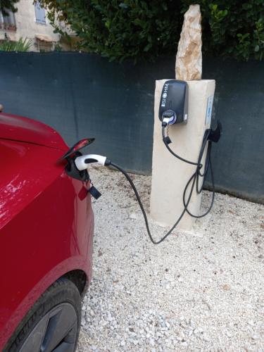 a car is hooked up to a electric car charger at Gîte de Fanny du Moulin de Tartay en Avignon in Avignon