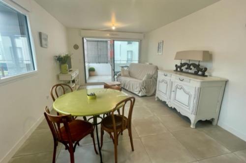 a living room with a table and chairs and a couch at Nice 66m with terrace in La Rochelle in La Rochelle