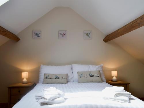 a bedroom with a bed with two towels on it at Yr Hen Feudy in Valley