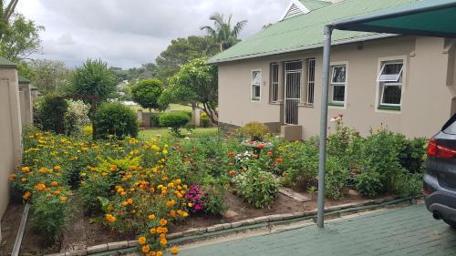 einen Garten vor einem Haus mit Blumen in der Unterkunft Repose Guest house! in King Williamʼs Town