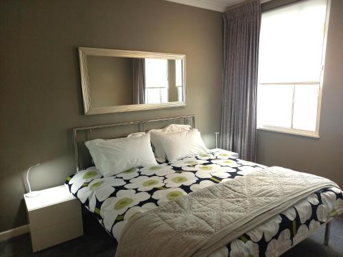 a bedroom with a bed and a mirror and a window at Heart of the city. Perfect for attractions & West End in London