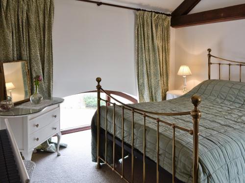 um quarto com uma cama, uma cómoda e uma janela em Farlam House Barn em Farlam
