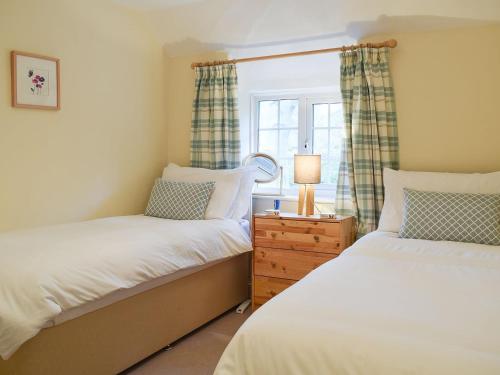 sypialnia z 2 łóżkami i oknem w obiekcie Westover Cottage w mieście Wootton