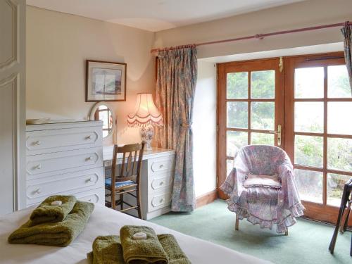 a bedroom with a bed and a dresser and a window at Rowan Tree Cottage - S4216 in Tulchan