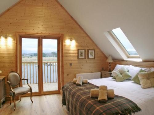 a bedroom with a bed and a balcony at Gairlochy Bay in Gairlochy
