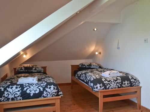 two beds in a attic room with stairs at Gwelfor in Trearddur