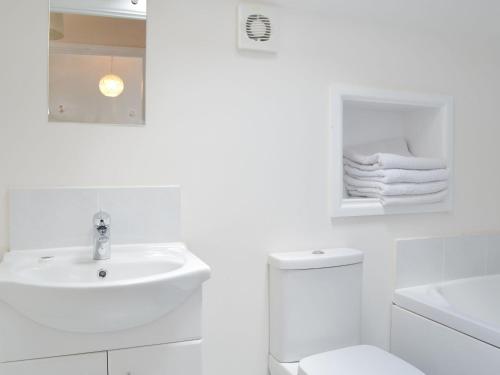 a white bathroom with a sink and a toilet at The Swallows - 28835 in Royal Wootton Bassett