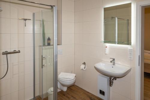 a bathroom with a toilet and a sink and a shower at Seewohnung "Rügen" in Gützkow