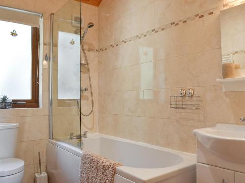 a bathroom with a shower and a tub and a sink at Larchwood in Ellonby