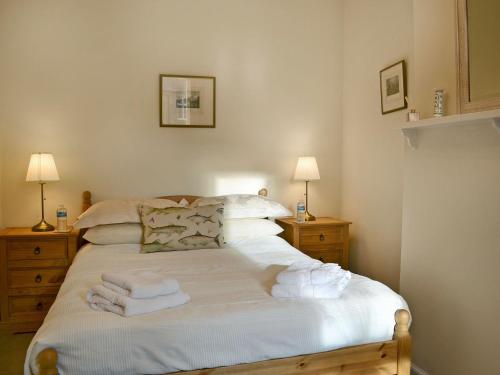 a bedroom with a bed with towels on it at Rose Cottage in Norham