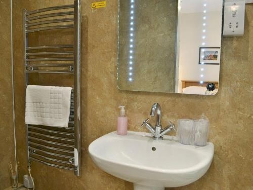 a bathroom with a sink and a mirror at Rose Cottage in Norham