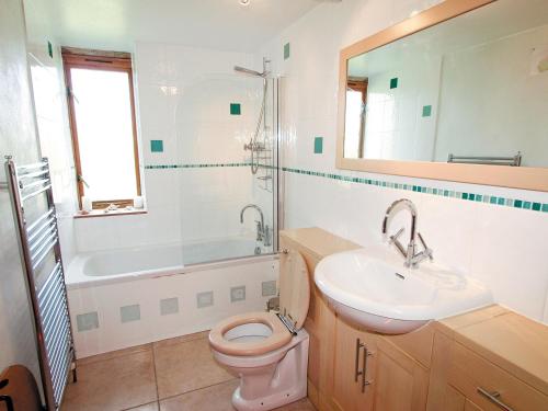 a bathroom with a toilet and a sink and a tub at The Old Dairy - E5394 in Whitchurch Canonicorum