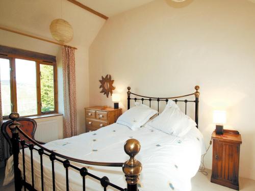 a bedroom with a large bed with white sheets at The Old Dairy - E5394 in Whitchurch Canonicorum