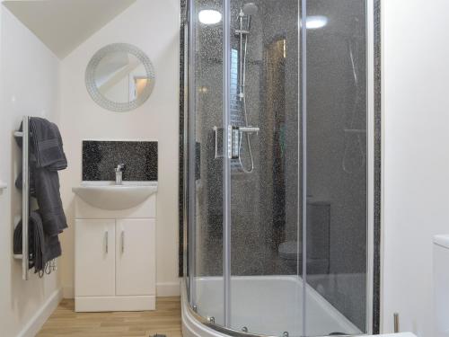 een badkamer met een glazen douche en een wastafel bij Hollys Barn in Brent Knoll