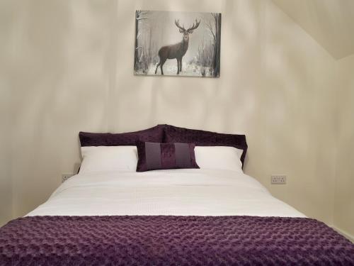 um quarto com uma cama com uma imagem de veado na parede em Hollys Barn em Brent Knoll