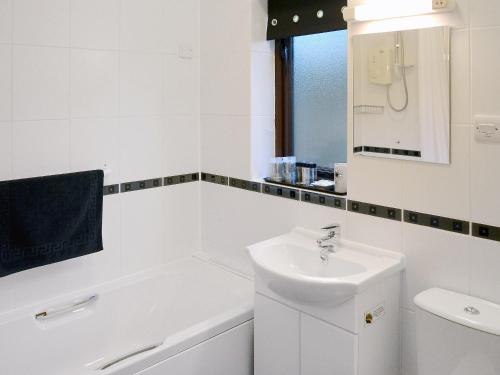 a white bathroom with a sink and a bath tub at Ash Lodge - Hw7442 in Nantmel
