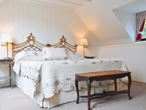 um quarto com uma cama grande e uma mesa em The Cottage em Stroud