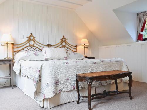 1 dormitorio con 1 cama grande y 1 mesa en The Cottage, en Stroud