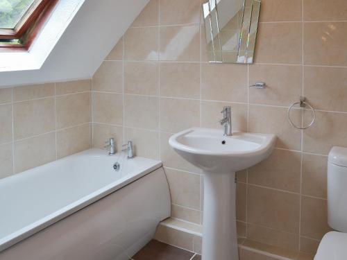 een badkamer met een wastafel, een toilet en een bad bij Rosecraddoc Manor - Lakeview in Saint Cleer
