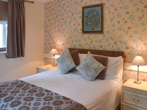 een slaapkamer met een bed met 2 nachtkastjes en 2 lampen bij Rosecraddoc Manor - Lakeview in Saint Cleer