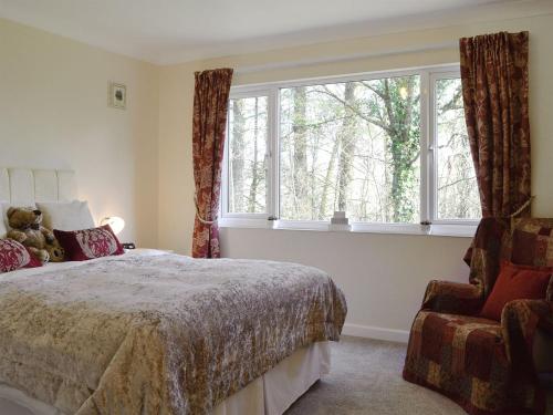 a bedroom with a bed and a window and a chair at Rowans in Cleator