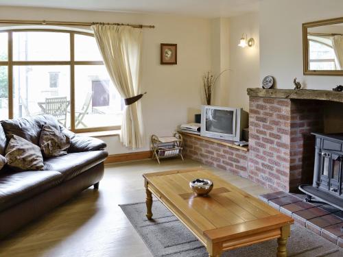 a living room with a couch and a fireplace at The Cottage - 28645 in Alston