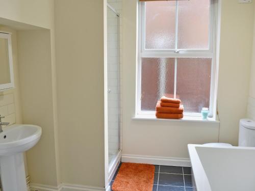 baño con lavabo y ventana con toallas en Samphire en Cromer