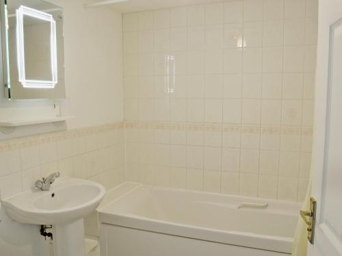 a white bathroom with a sink and a bath tub at Meadow Cottage-e1793 in Broadwindsor