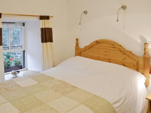 a bedroom with a bed and a window at Meadow Cottage in St. Just