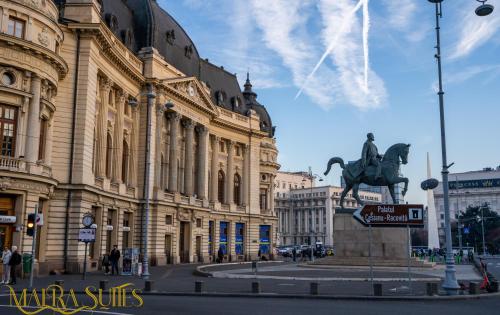 una statua di un uomo a cavallo di fronte a un edificio di MAERA Suites Central a Bucarest