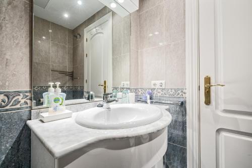 ein Badezimmer mit einem weißen Waschbecken und einem Spiegel in der Unterkunft Magnifique appartement super équipé avec belle vue mer in Sitio de Calahonda
