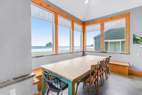 a dining room with a table and chairs and the ocean at Pacific City Ocean Front Escape in Pacific City