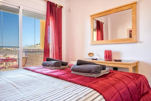 Schlafzimmer mit einem Bett mit einem Spiegel und einem Fenster in der Unterkunft Magnifique appartement super équipé avec belle vue mer in Sitio de Calahonda