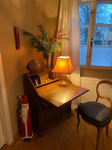 a room with a desk with a lamp and a cat statue at Alexandrowka Wohnen im UNESCO Weltkulturerbe Haus in Potsdam