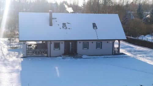 a house with snow on the roof of it at Sielska Dolina pod Ślężą in Mysłaków
