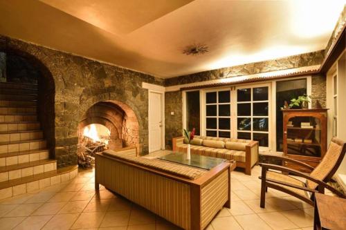 a living room with a fireplace and a couch at Mystic Mayapott, Thekkady in Thekkady