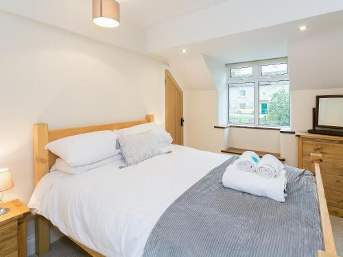 1 dormitorio con 1 cama blanca grande y toallas. en Manor Cottage, en Tideswell