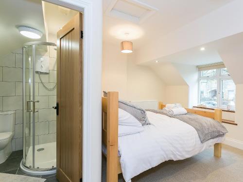 1 dormitorio con cama y ducha en Manor Cottage, en Tideswell