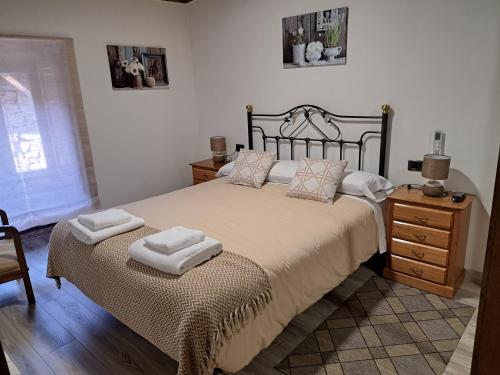 a bedroom with a bed with two towels on it at Casa do sequeiro in Parada del Sil